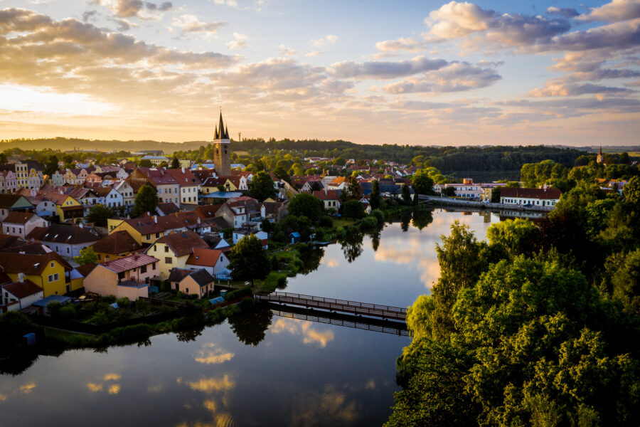 Část historického centra města Telče, věž sv. Ducha a Belpská lávka přes Ulický rybník na leteckém snímku pořízeném dronem, 7. července 2023, Telč, Vysočina.
